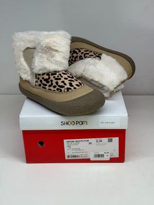 les chaussures sont posées sur la boîte, sur la surface blanche
