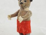 a small teddy bear that is dressed in a red skirt
