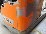 une machine orange qui se trouve dans le garage