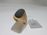 une bague en or sertie d'une pierre noire