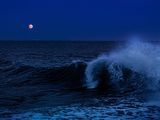 les vagues qui déferlent dans l'océan la nuit, sous une pleine lune