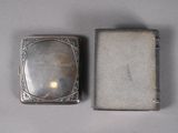 an old silver cigarette case sitting on top of a white cloth