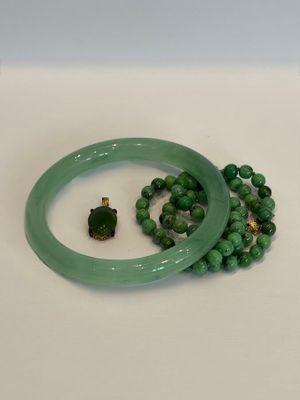 deux bracelets verts et une tortue verte sur un fond blanc