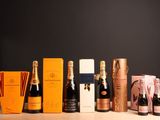 plusieurs bouteilles de champagne posées sur une table, à côté d'une boîte de chocolats