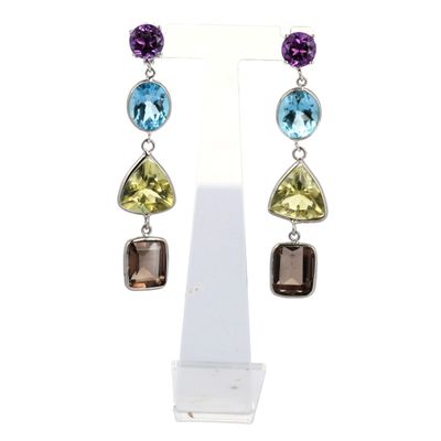 une paire de boucles d'oreilles ornées de pierres multicolores qui pendent