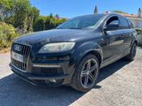 a black audi qx parked in a parking lot