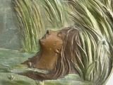 a statue of a woman swimming in a lake