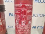 a fire extinguisor on the table next to other fire extinguisors