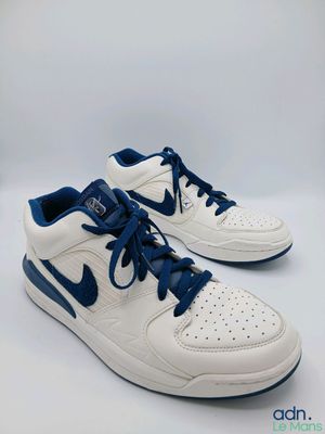 une paire de baskets blanches et bleues avec des lacets bleus