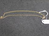 un collier en or auquel est attachée une médaille