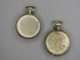 deux montres de poche en argent posées l'une à côté de l'autre sur une table