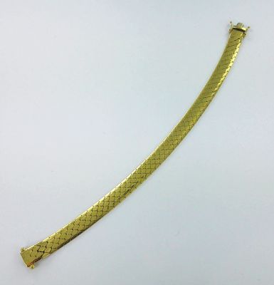 un bracelet plaqué or avec un motif en peau de serpent