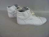 pair of white puma sneakers with grey laces on a white surface