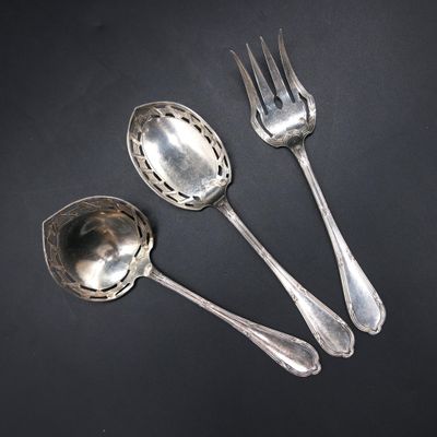 three silver spoons and a fork on a black surface