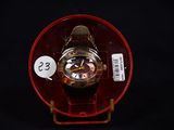 a watch sitting on a red plate with a price tag on it