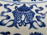 a blue and white vase with a fish design on it
