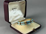 an image of a gold and turquoise bracelet in a case