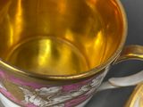 a gold cup and saucer sitting on a table