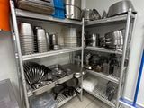 de nombreuses casseroles et poêles sur les étagères de la cuisine