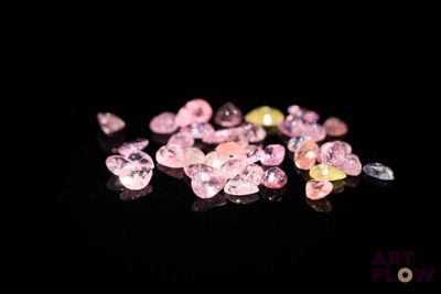 some pink and yellow diamonds are on a black surface