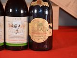 three bottles of wine sitting on a table with a red table cloth