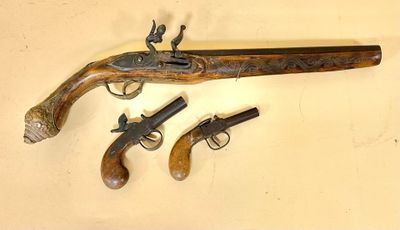 two old guns are displayed on a wall next to each other