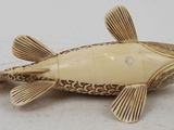 an image of a carved fish sitting on top of a white surface