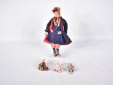 une figurine représentant une femme en robe bleue et trois petits chiens