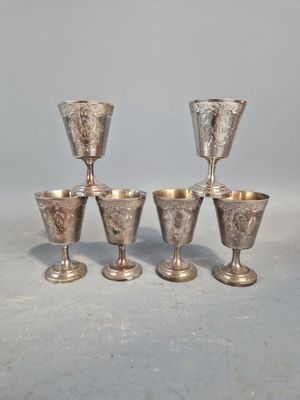quatre gobelets en argent posés les uns à côté des autres sur une table