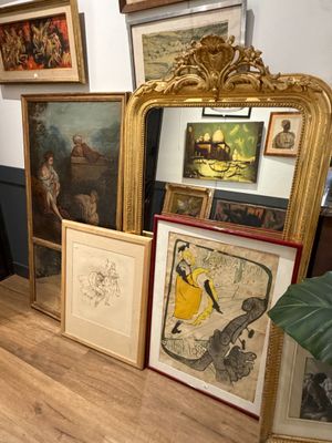 Il y a beaucoup d'œuvres d'art encadrées posées par terre dans cette pièce