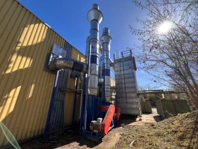 un tuyau bleu sur le côté d'un immeuble, à côté d'un immeuble jaune