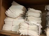 plusieurs piles de serviettes blanches pliées sur une étagère dans un magasin