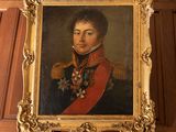 Un portrait d'un homme en uniforme militaire est accroché au mur.
