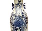 a blue and white vase with a bird on it