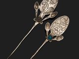 deux cuillères en argent ornées de pierres bleues sur fond noir