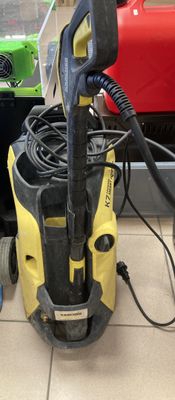 un presseur jaune et noir posé par terre à côté d'une machine rouge et verte