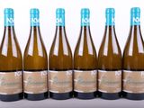 six bouteilles de vin sont alignées sur une surface blanche