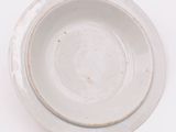 a white plate with a brown rim on a white table