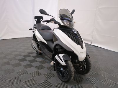 a white and black motorcycle parked on a black and white checkered floor