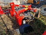 un tracteur immobilisé dans l'herbe, avec une charrue attelée derrière lui