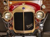 a red and gold car parked in front of a brick wall