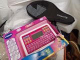 a pink electronic keyboard sitting on top of a pile of toys