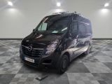 la photo d'une camionnette noire garée sur un sol en damier