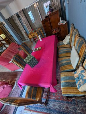 un salon avec des canapés et une table recouverte d'une nappe rose