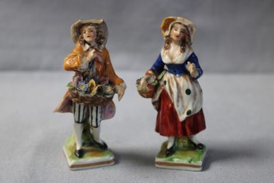 pair of figurines of two women with baskets of flowers