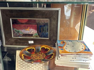 une vitrine en verre sur laquelle sont posés un bol et une horloge