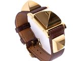 a watch with a brown leather band and a gold plated watch face