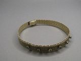 bracelet en argent orné de pointes et de perles sur un fond gris