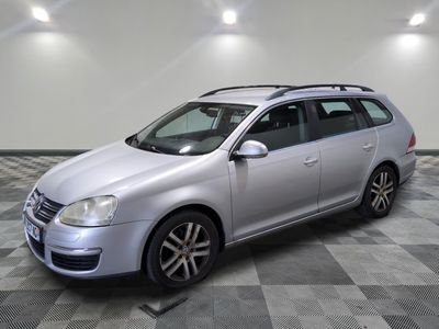 the silver volkswagen golf wagon is parked on a checkered floor