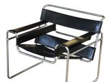 the black leather chair is sitting on a metal frame